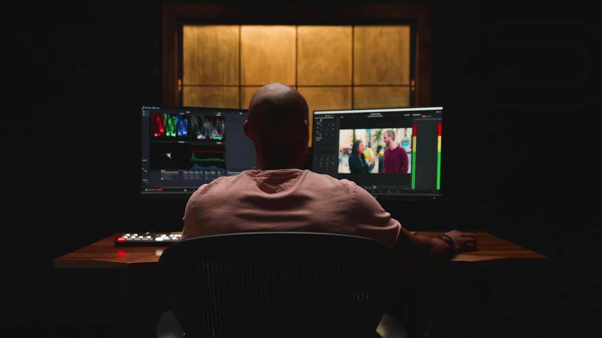 Man reviewing footage on dual monitors