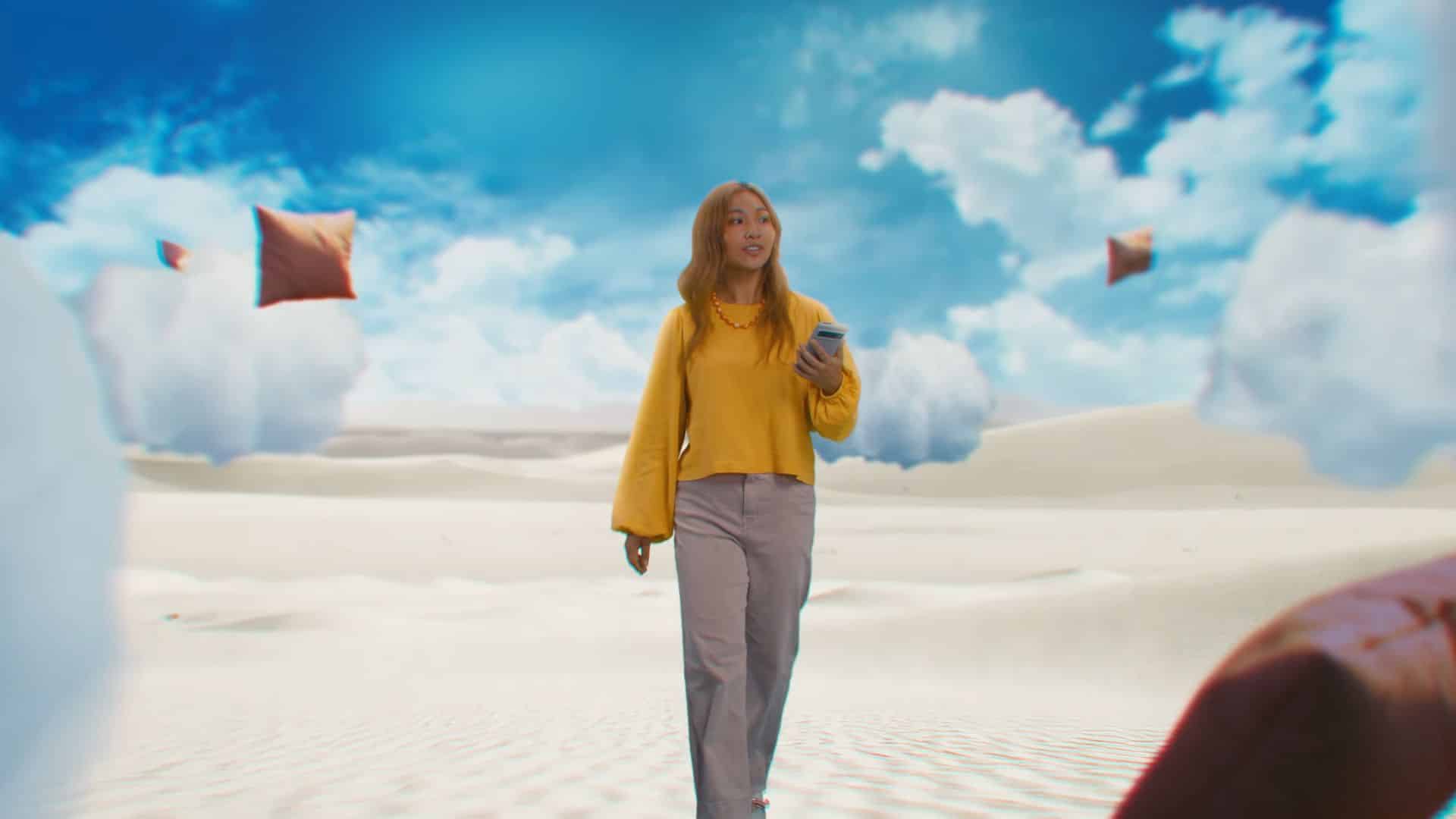 A woman in a yellow top walks through a surreal desert
