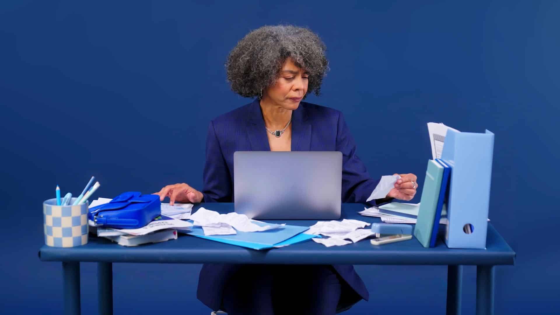 Woman in a blue suit working at a desk
