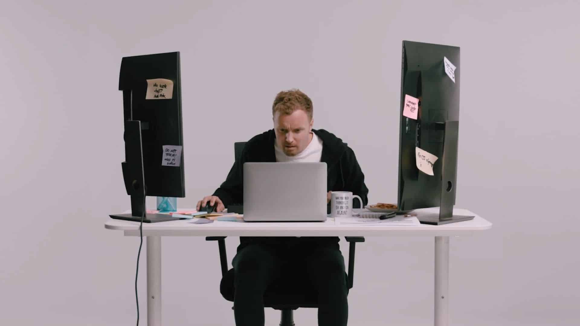 Person working at a desk between two monitors (1)