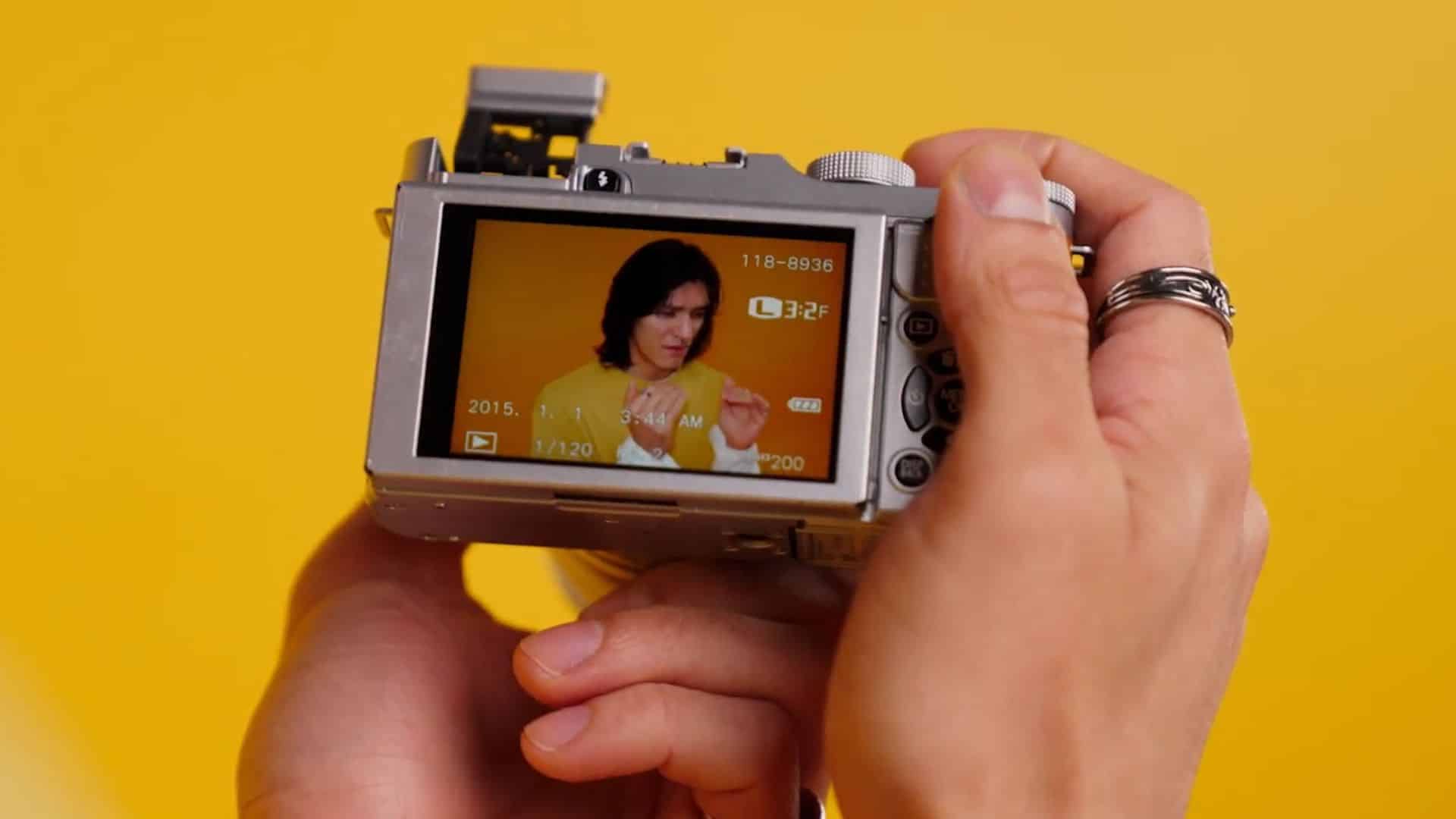 Close-up of a camera recording a person on a yellow set